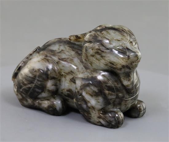 A Chinese pale grey and black jade recumbent figure of a lion-dog, length 8.3cm